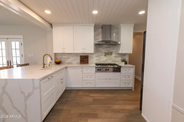 a kitchen with granite countertop white cabinets and white appliances