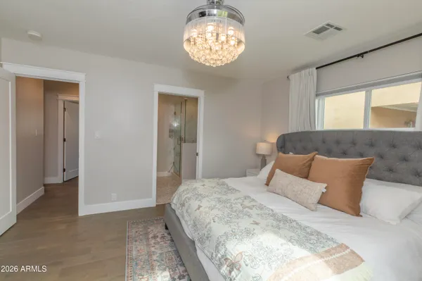 a bedroom with a bed and a chandelier