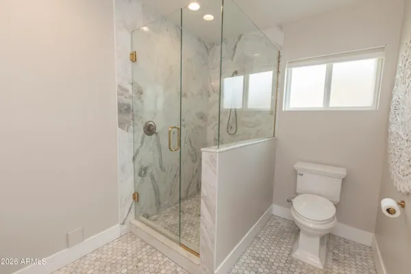 a bathroom with a granite countertop sink a toilet and shower