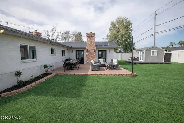 a backyard of a house with table and chairs