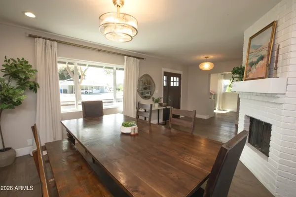 a dining room with wooden floor a chandelier a glass table and chairs