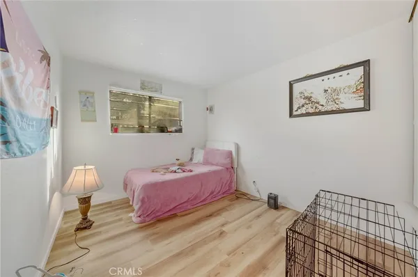 a bedroom with a bed and a lamp on dresser