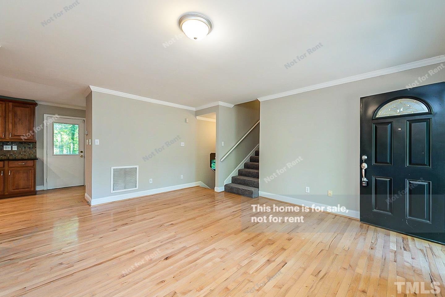 916 East Millbrook Road Raleigh, NC 27609 - Photo 2 of 24 an empty room with wooden floor and stairs