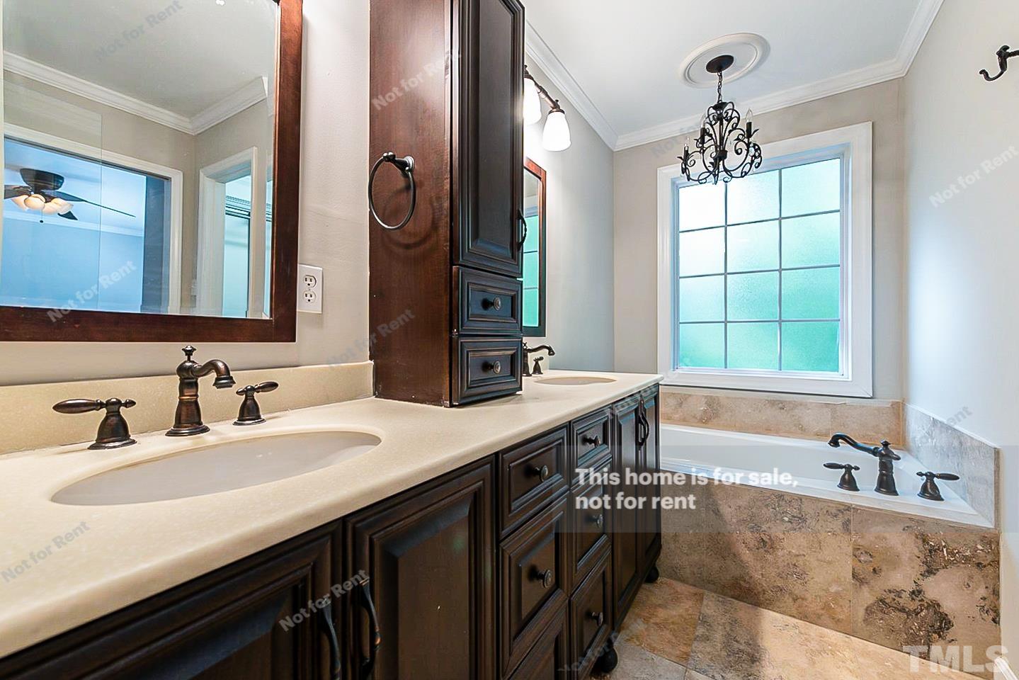 916 East Millbrook Road Raleigh, NC 27609 - Photo 14 of 24 a bathroom with a granite countertop sink a large mirror a bathtub and window