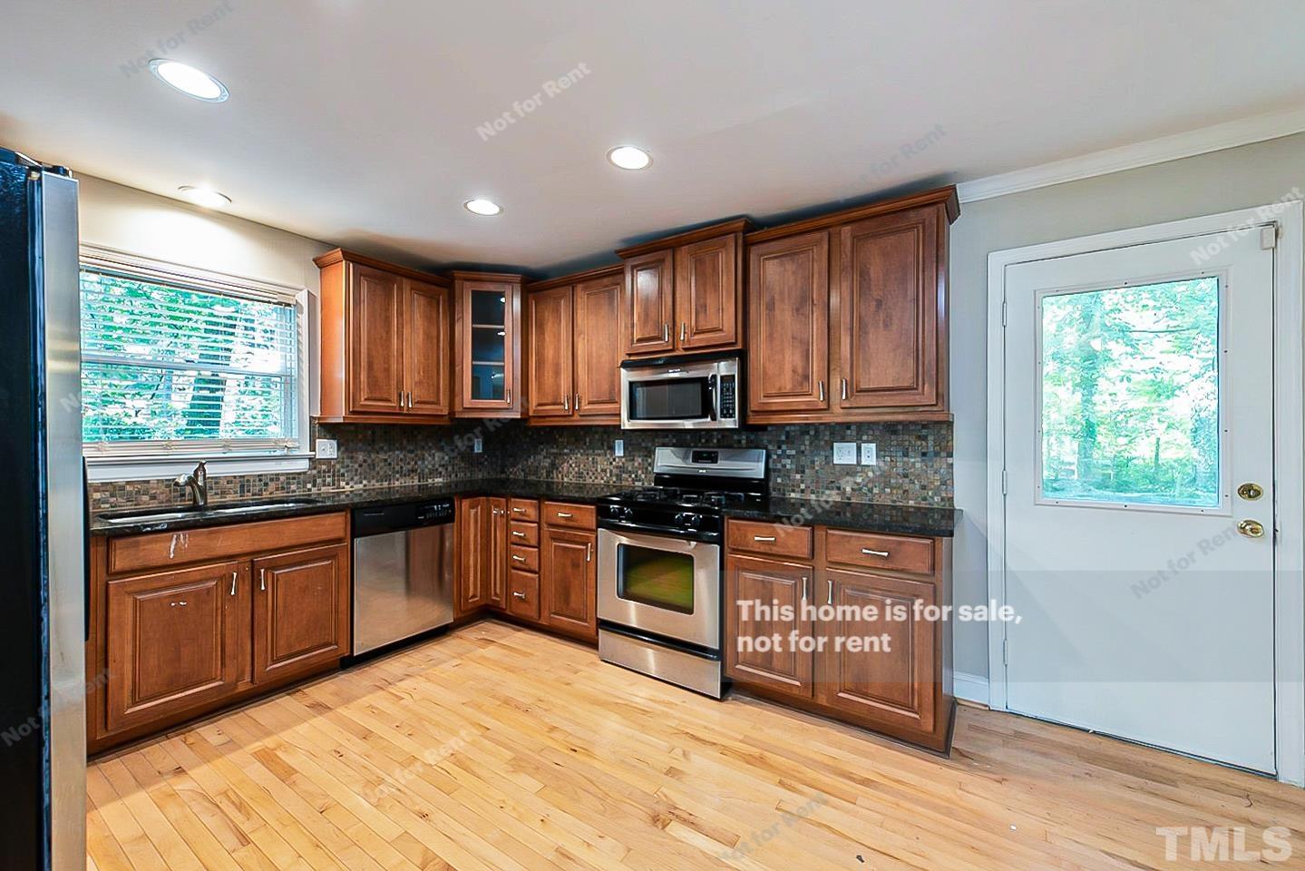 916 East Millbrook Road Raleigh, NC 27609 - Photo 5 of 24 a kitchen with stainless steel appliances granite countertop wooden cabinets a sink and a stove