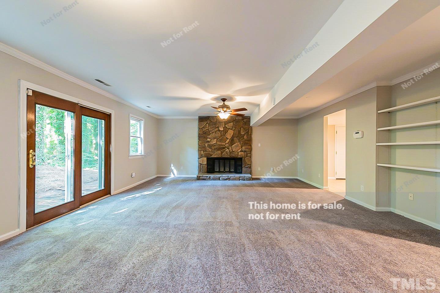 916 East Millbrook Road Raleigh, NC 27609 - Photo 10 of 24 a view of an empty room with a fireplace and a window