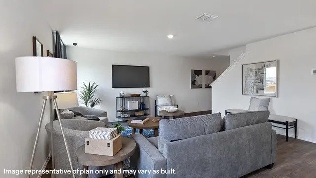 a living room with furniture a lamp and a flat screen tv