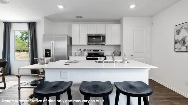 a kitchen with stainless steel appliances a dining table and chairs