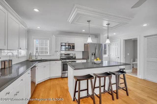 a kitchen with stainless steel appliances a table chairs refrigerator and microwave