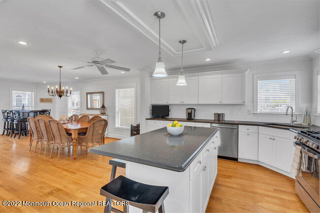 63 Fort Avenue Seaside Heights, NJ 08751 - Photo 13 of 53 a kitchen with stainless steel appliances granite countertop a stove top oven a sink a dining table and chairs with wooden floor