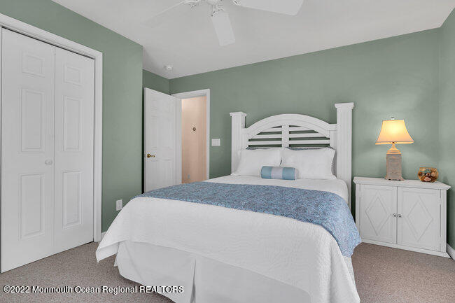 63 Fort Avenue Seaside Heights, NJ 08751 - Photo 22 of 53 a spacious bedroom with a bed and a lamp