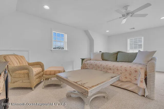 a spacious bedroom with a bed a couch and a dresser in it