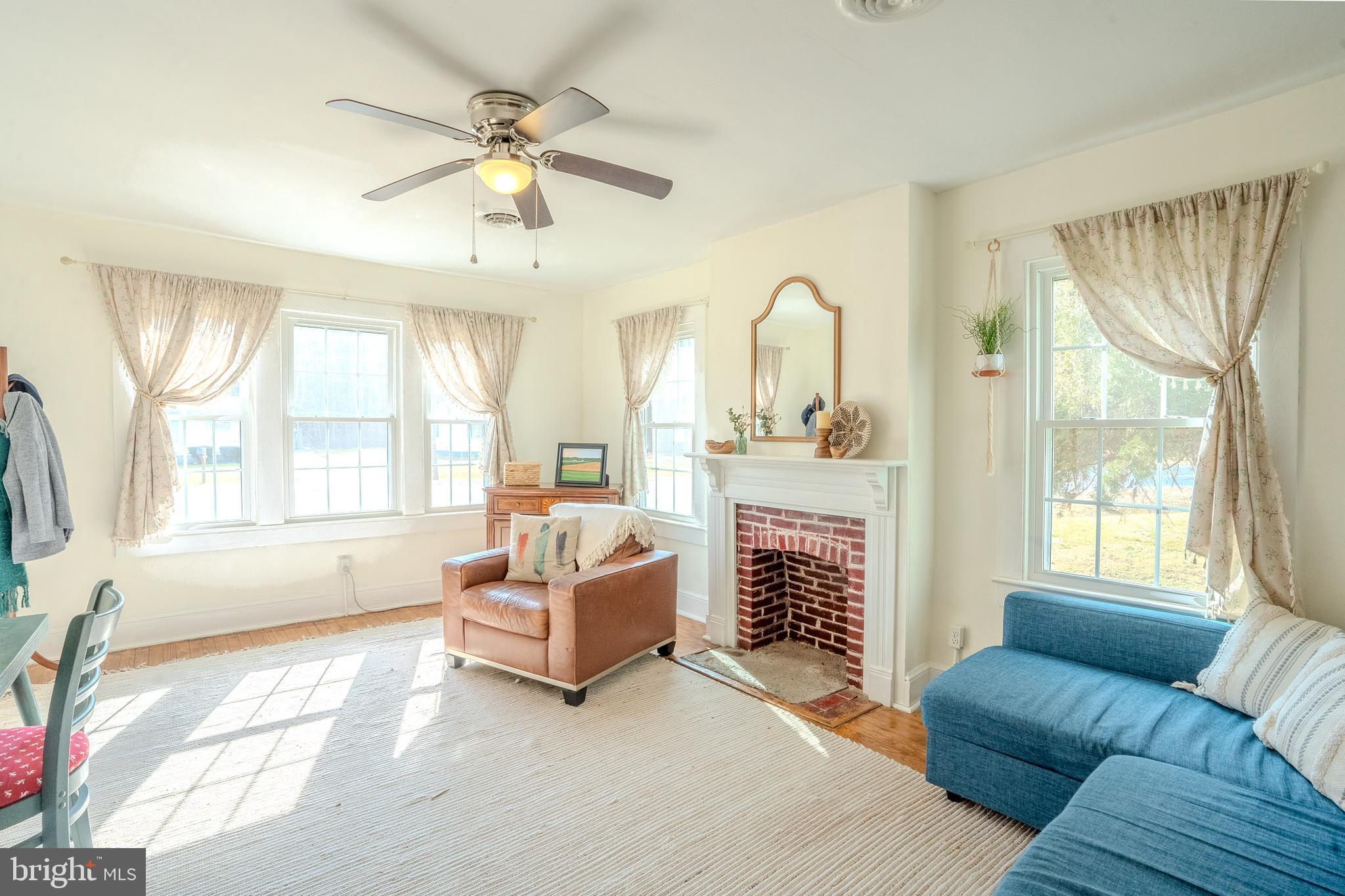 27209 Saxis Road Temperanceville, VA 23442 - Photo 14 of 31 a living room with fireplace furniture and a large window