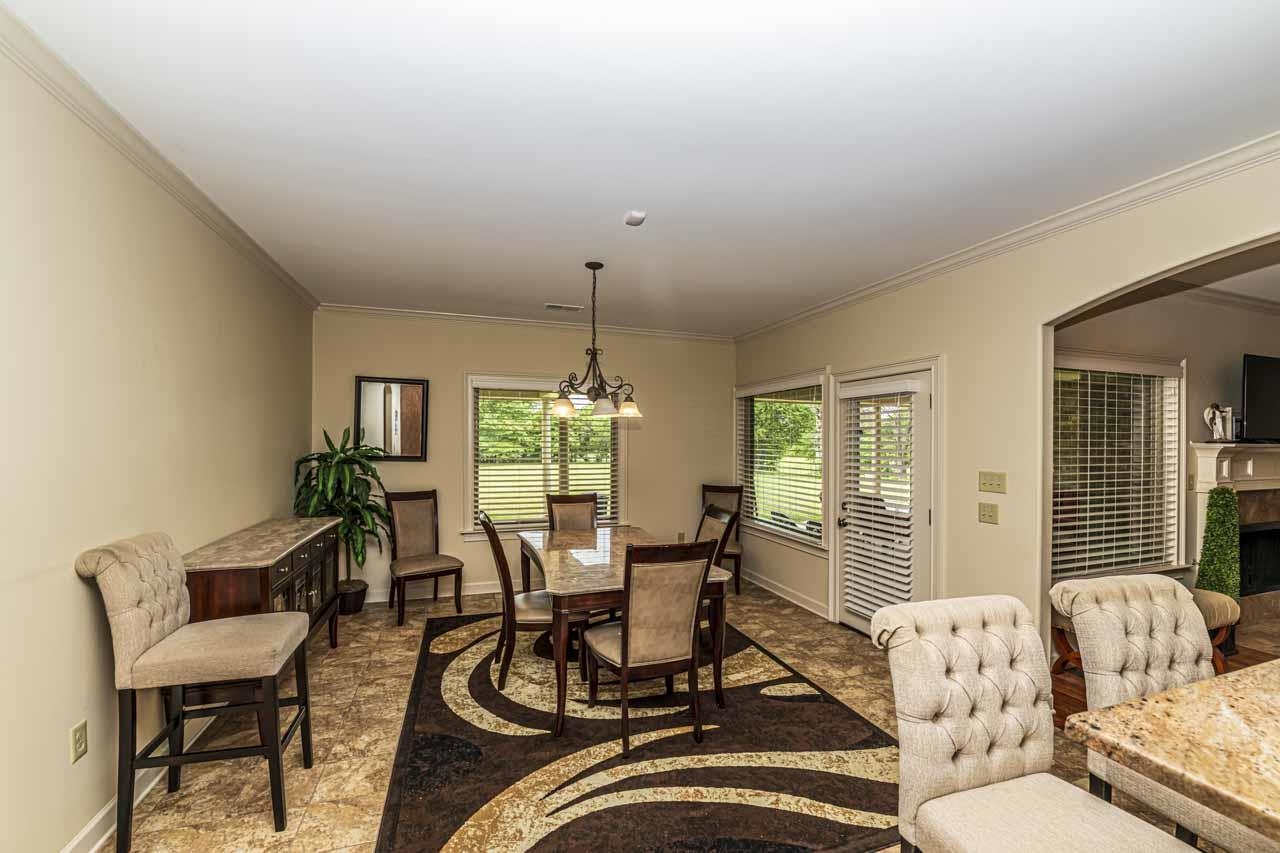 185 Belmont Road Mason, TN 38049 - Photo 21 of 38 Dining area featuring crown molding, a multi-light chandelier, and tile flooring