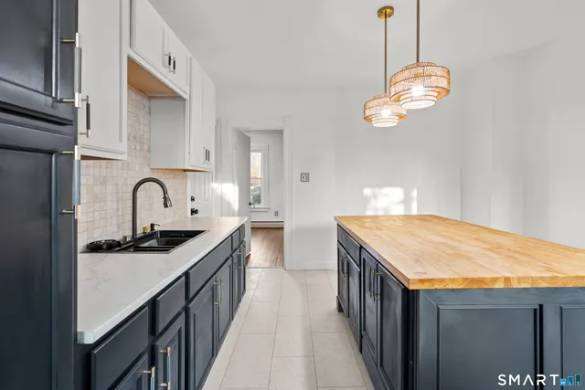 a kitchen with kitchen island stainless steel appliances granite countertop a sink a stove and a wooden floors