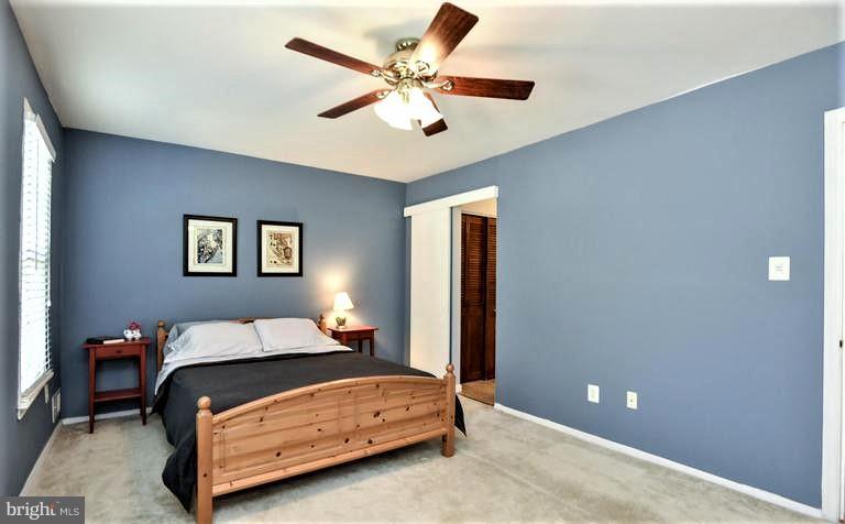 2406 Wanda Way Reston, VA 20191 - Photo 14 of 30 a bedroom with a bed and a chandelier