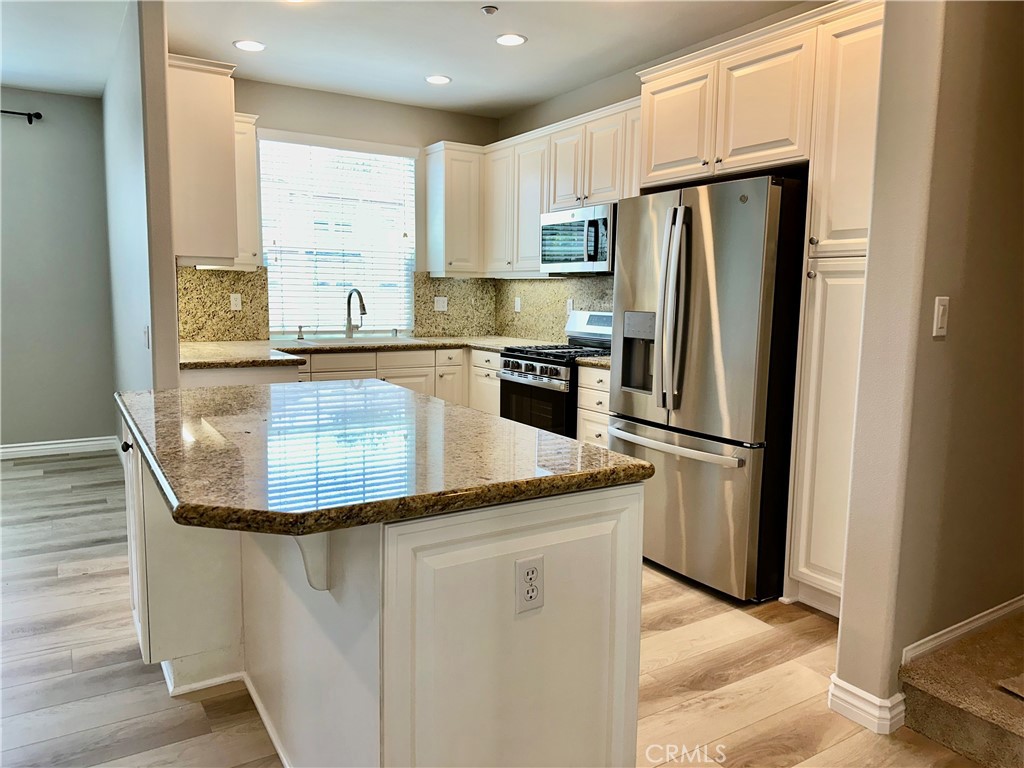 21 Durlston Way Ladera Ranch, CA 92694 - Photo 11 of 47 a kitchen with stainless steel appliances granite countertop a refrigerator a stove a sink and a refrigerator