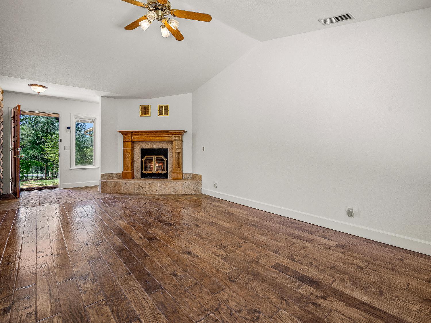 6460 Claim Street Placerville, CA 95667 - Photo 46 of 86 an empty room with windows fireplace and wooden floor