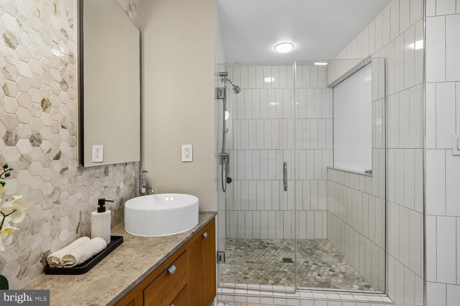 2370 Champlain Street Northwest, Unit 35 Washington, DC 20009 - Photo 31 of 49 a bathroom with a granite countertop sink a toilet and shower