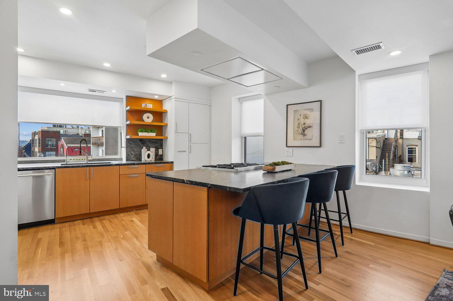 2370 Champlain Street Northwest, Unit 35 Washington, DC 20009 - Photo 9 of 49 a kitchen with stainless steel appliances granite countertop wooden floors and white cabinets