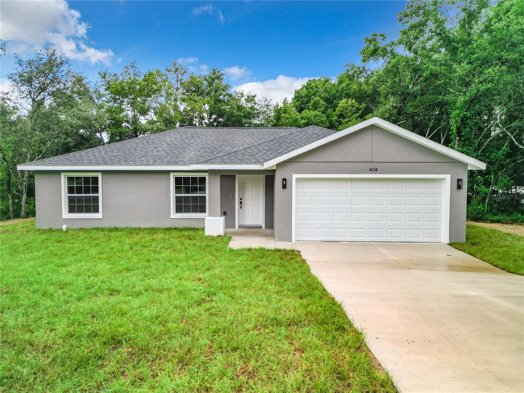 2688 Southwest Wave Lane Dunnellon, FL 34431 - Photo 1 of 1 a front view of a house with a yard and garage
