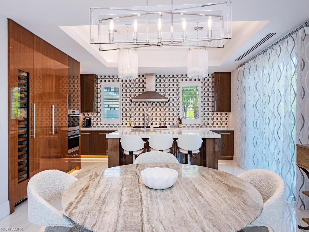490 5th Street South, Unit 101 Naples, FL 34102 - Photo 6 of 34 a living room with furniture and a chandelier