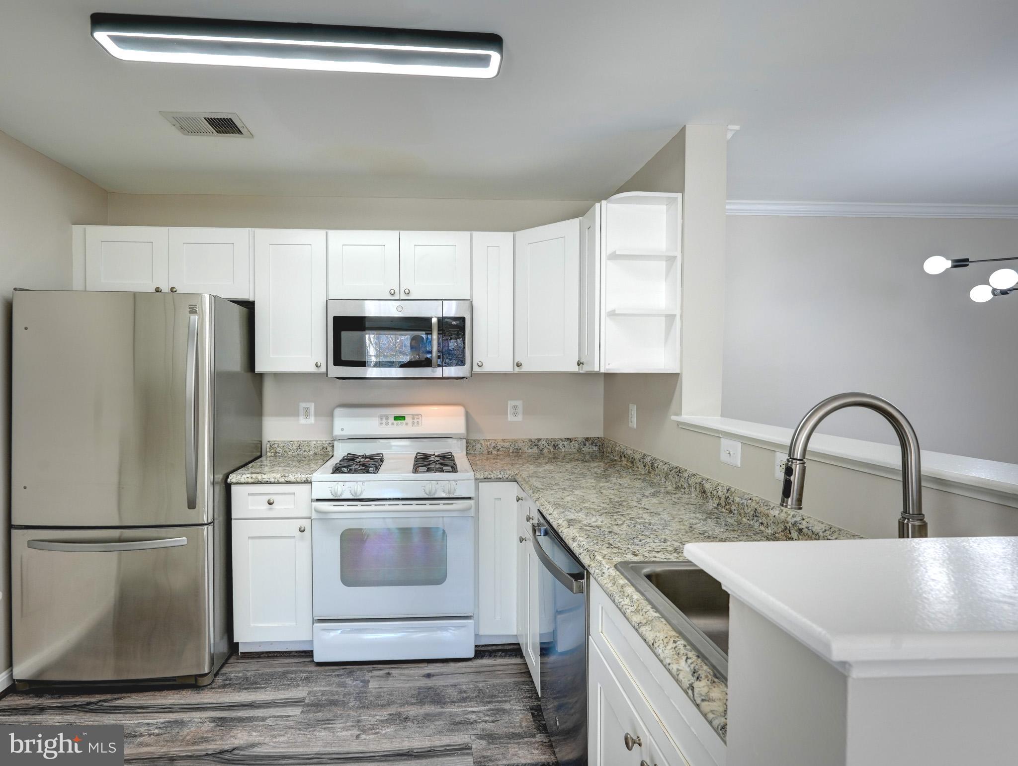 1001 Gaither Road, Unit I Rockville, MD 20850 - Photo 17 of 34 a kitchen with a refrigerator sink and cabinets