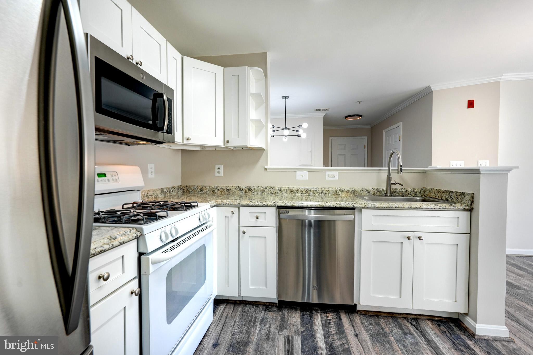 1001 Gaither Road, Unit I Rockville, MD 20850 - Photo 18 of 34 a kitchen with stainless steel appliances granite countertop a stove a sink and a microwave