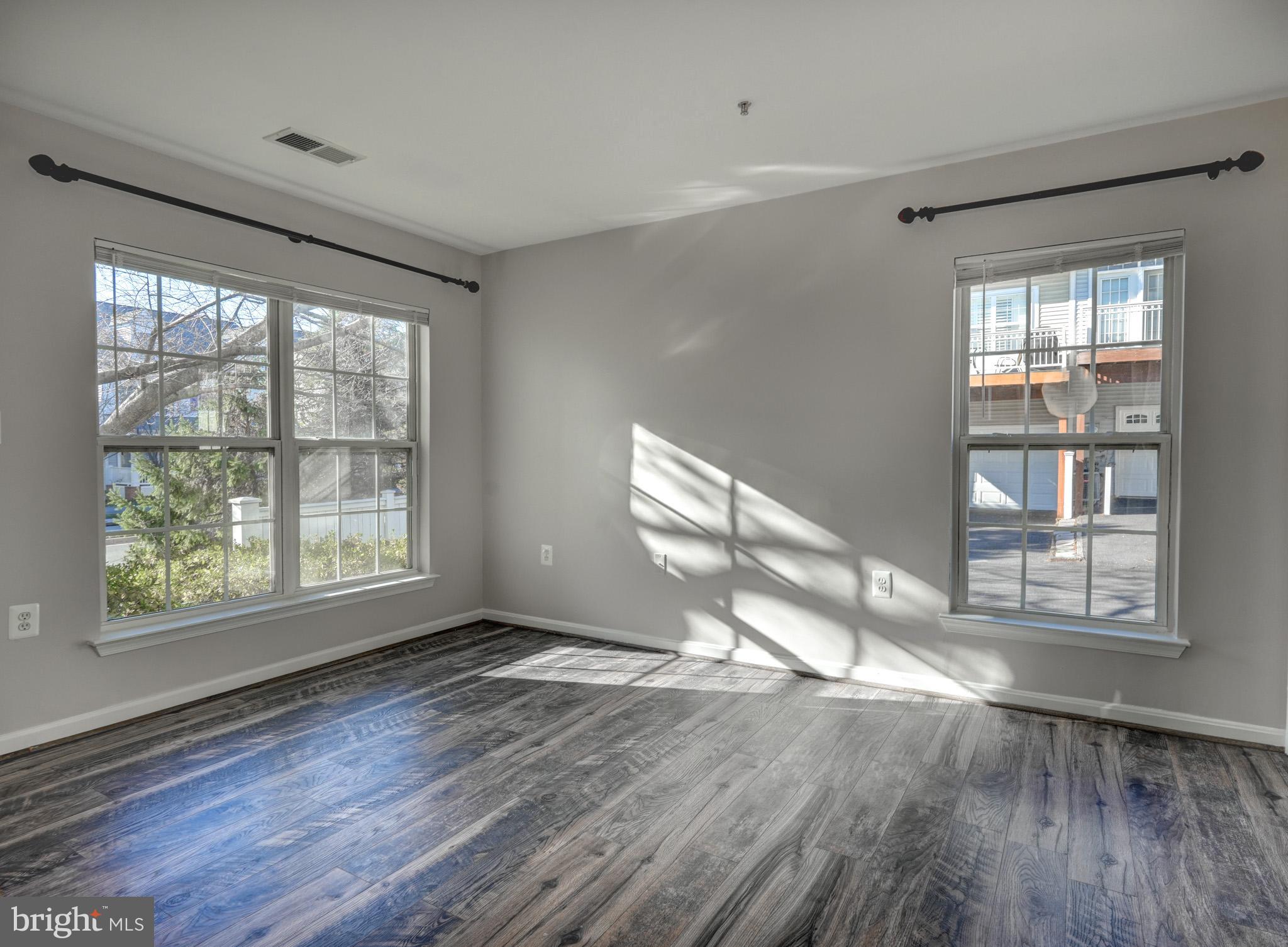 1001 Gaither Road, Unit I Rockville, MD 20850 - Photo 22 of 34 an empty room with wooden floor and windows