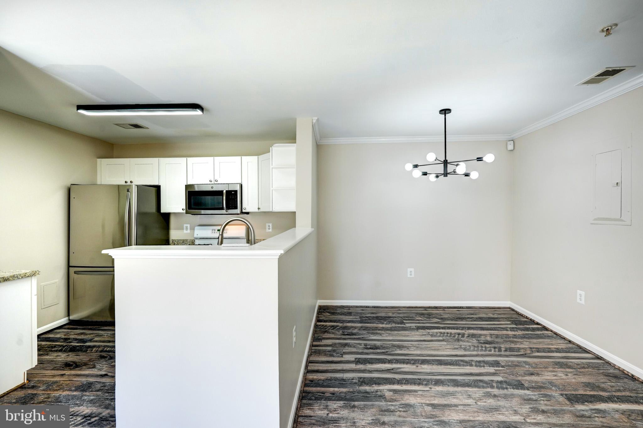 1001 Gaither Road, Unit I Rockville, MD 20850 - Photo 27 of 34 a view of kitchen and empty room with wooden floor