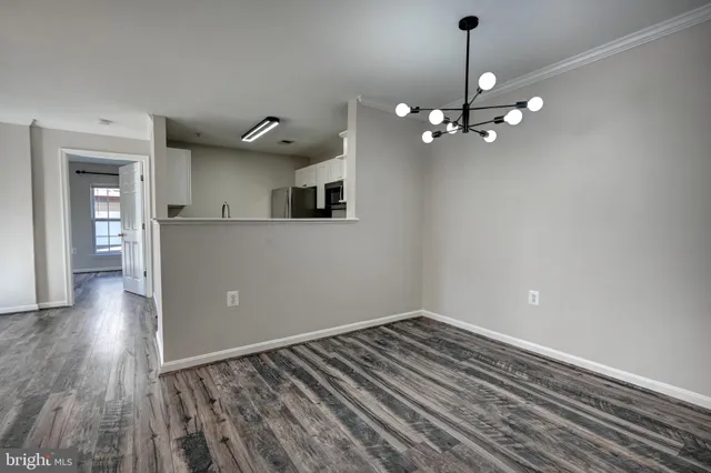 a view of empty room with wooden floor and ceiling fan