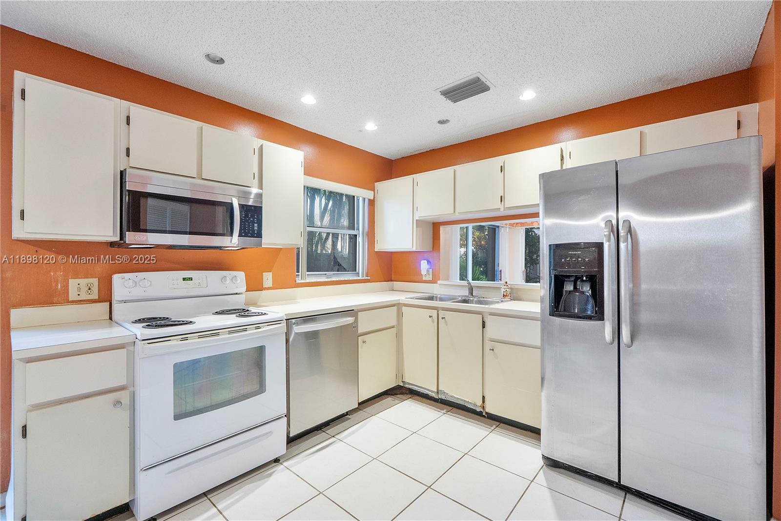 9870 Northwest 2nd Street Plantation, FL 33324 - Photo 5 of 12 a kitchen with white cabinets stainless steel appliances and a counter top space