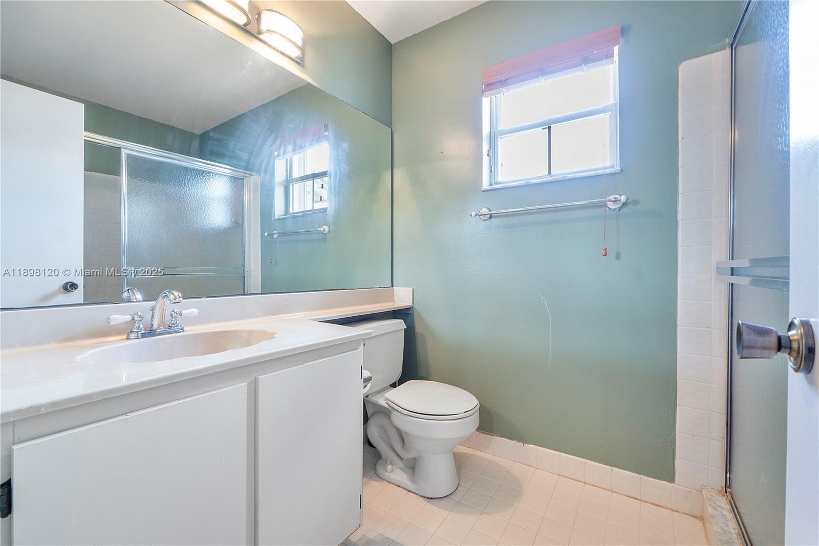 9870 Northwest 2nd Street Plantation, FL 33324 - Photo 8 of 12 a bathroom with a granite countertop sink a toilet and a mirror