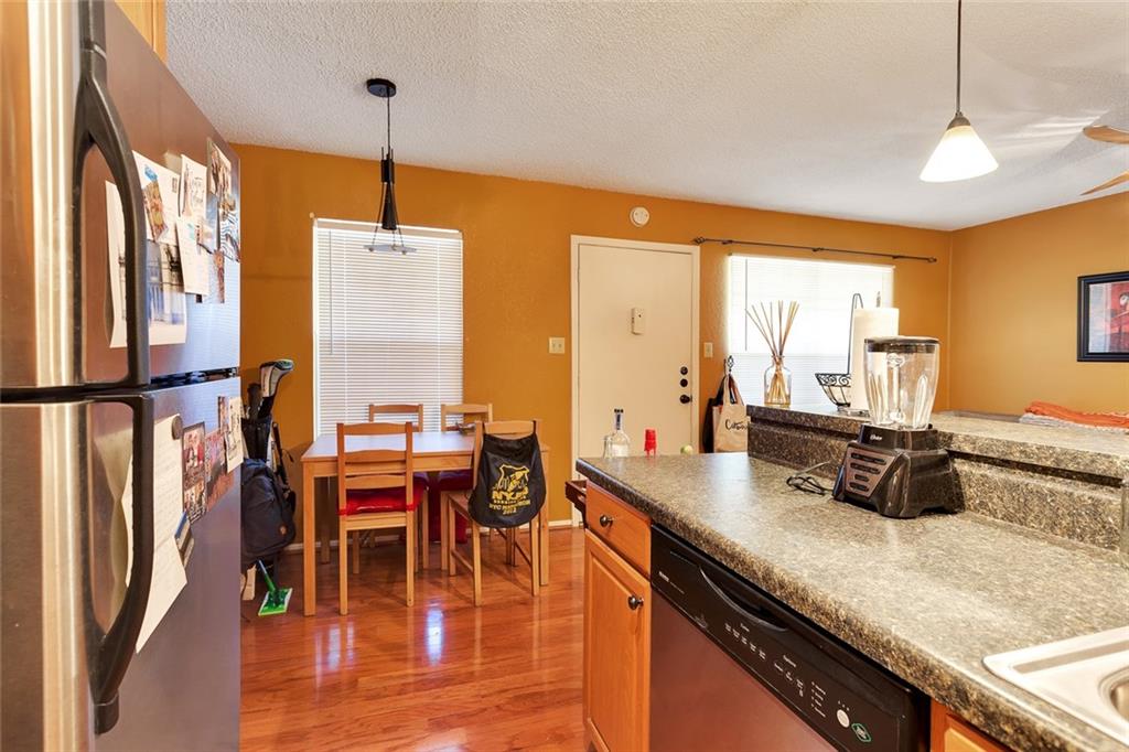 910 Duncan Lane, Unit 35 Austin, TX 78705 - Photo 10 of 20 A well-lit kitchen with rich hardwood flooring and durable countertops, perfect for everyday living.