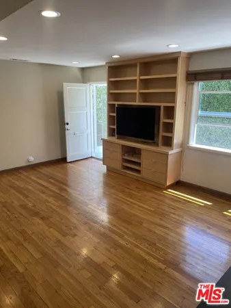an empty room with wooden floor and a window