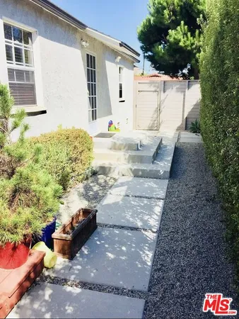 a view of a backyard with table and chairs and potted plants