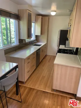 a kitchen with a sink a window and chairs