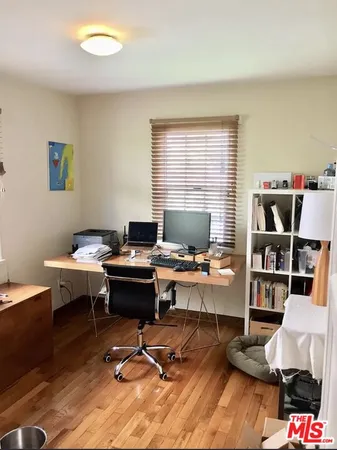 a view of a workspace with furniture and a window