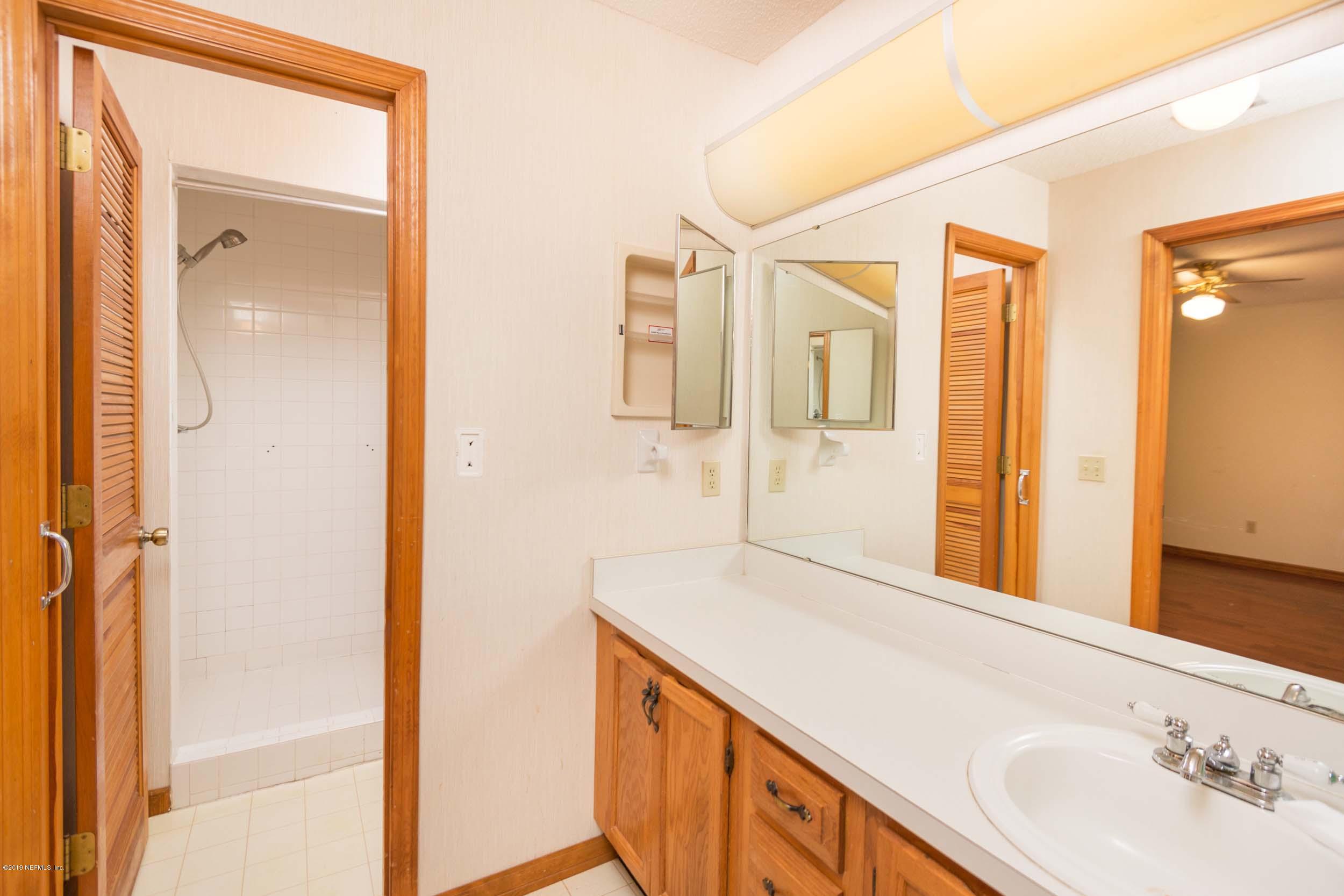 702 Miranda Road St. Augustine, FL 32086 - Photo 24 of 37 a bathroom with a sink a mirror and a shower