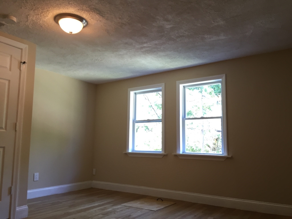31 Pine Street Dedham, MA 02026 - Photo 2 of 11 an empty room with wooden floor and windows