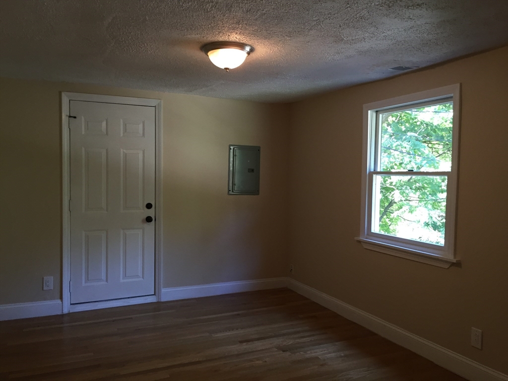 31 Pine Street Dedham, MA 02026 - Photo 3 of 11 an empty room with wooden floor closet and windows