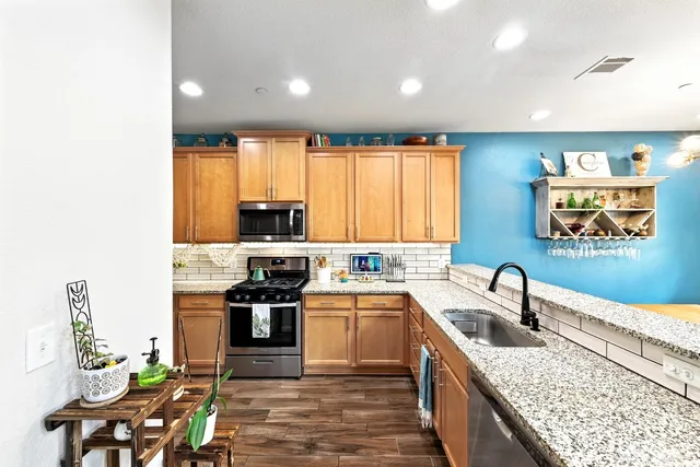 a kitchen with stainless steel appliances granite countertop a sink and a stove