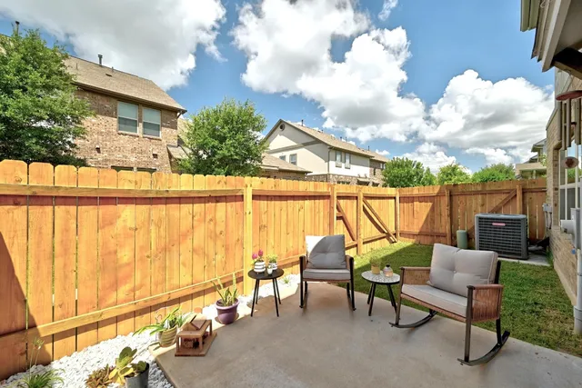 a view of a chair and table in backyard of the house