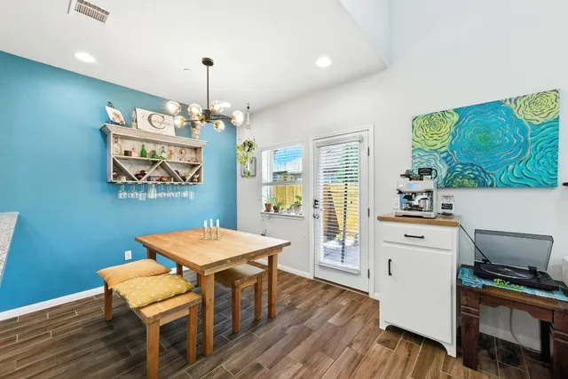a kitchen that has a table chairs and a wooden floor