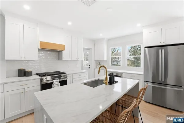 a kitchen with a sink a refrigerator and cabinets
