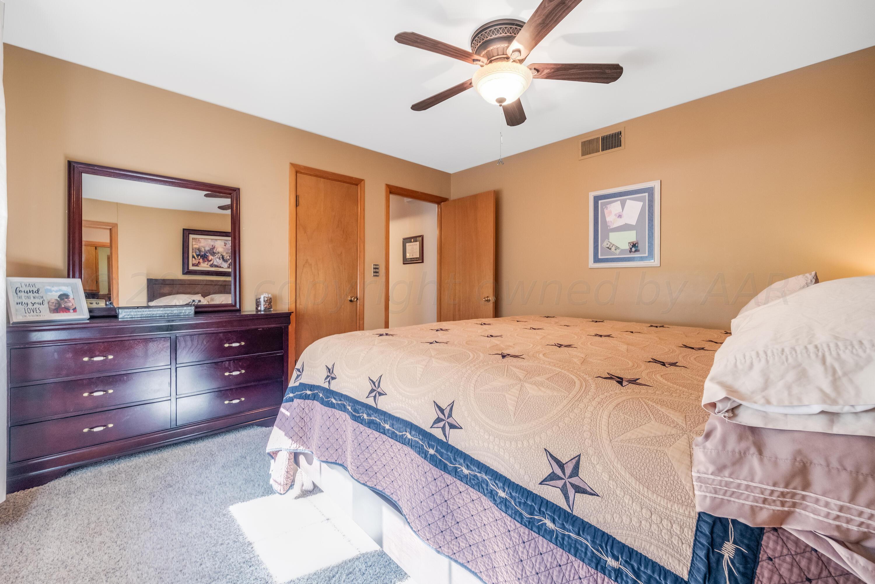 511 Cheyenne Street Wheeler, TX 79096 - Photo 24 of 45 a bedroom with a large bed and a chandelier