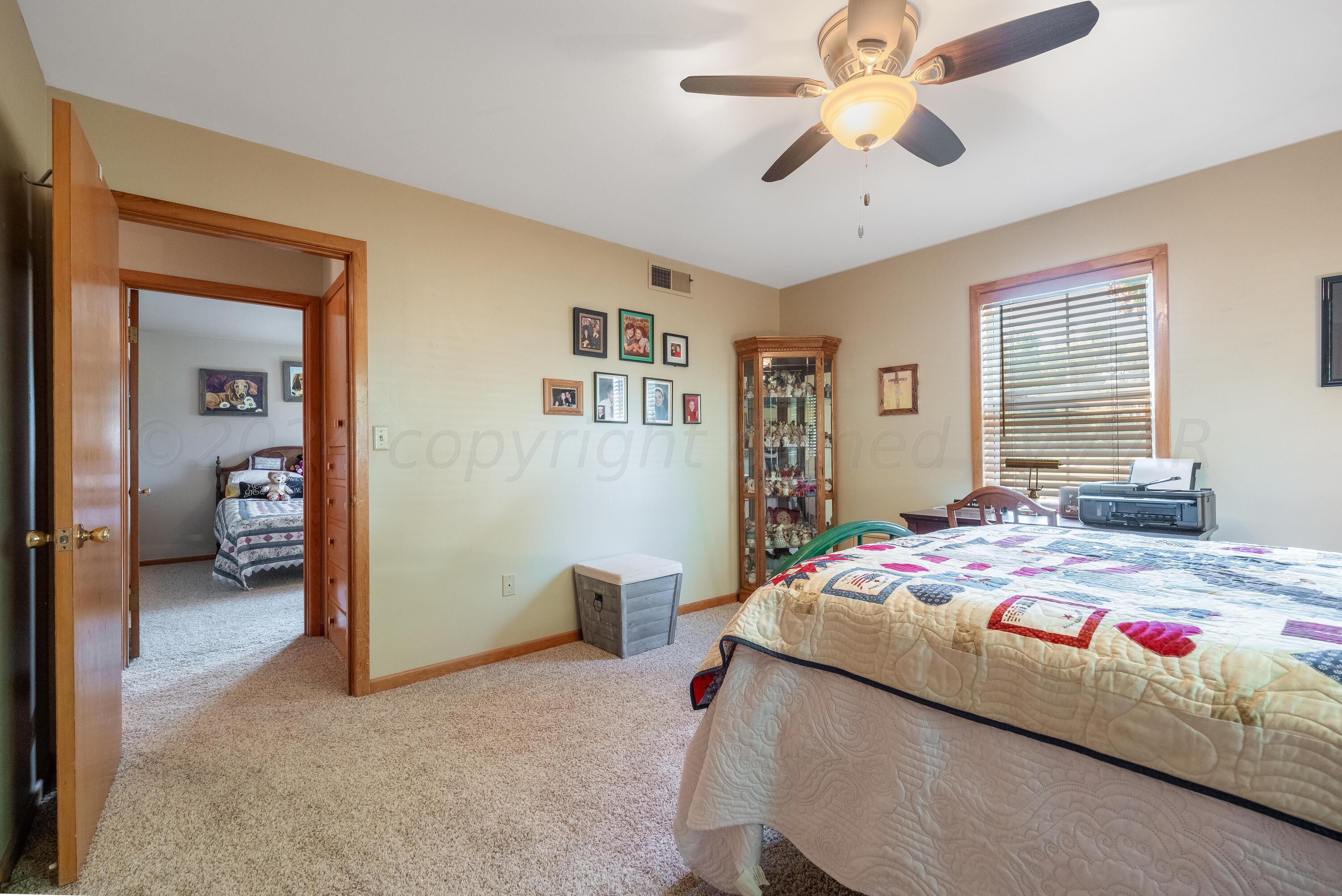 511 Cheyenne Street Wheeler, TX 79096 - Photo 31 of 45 a bedroom with a bed and a chandelier