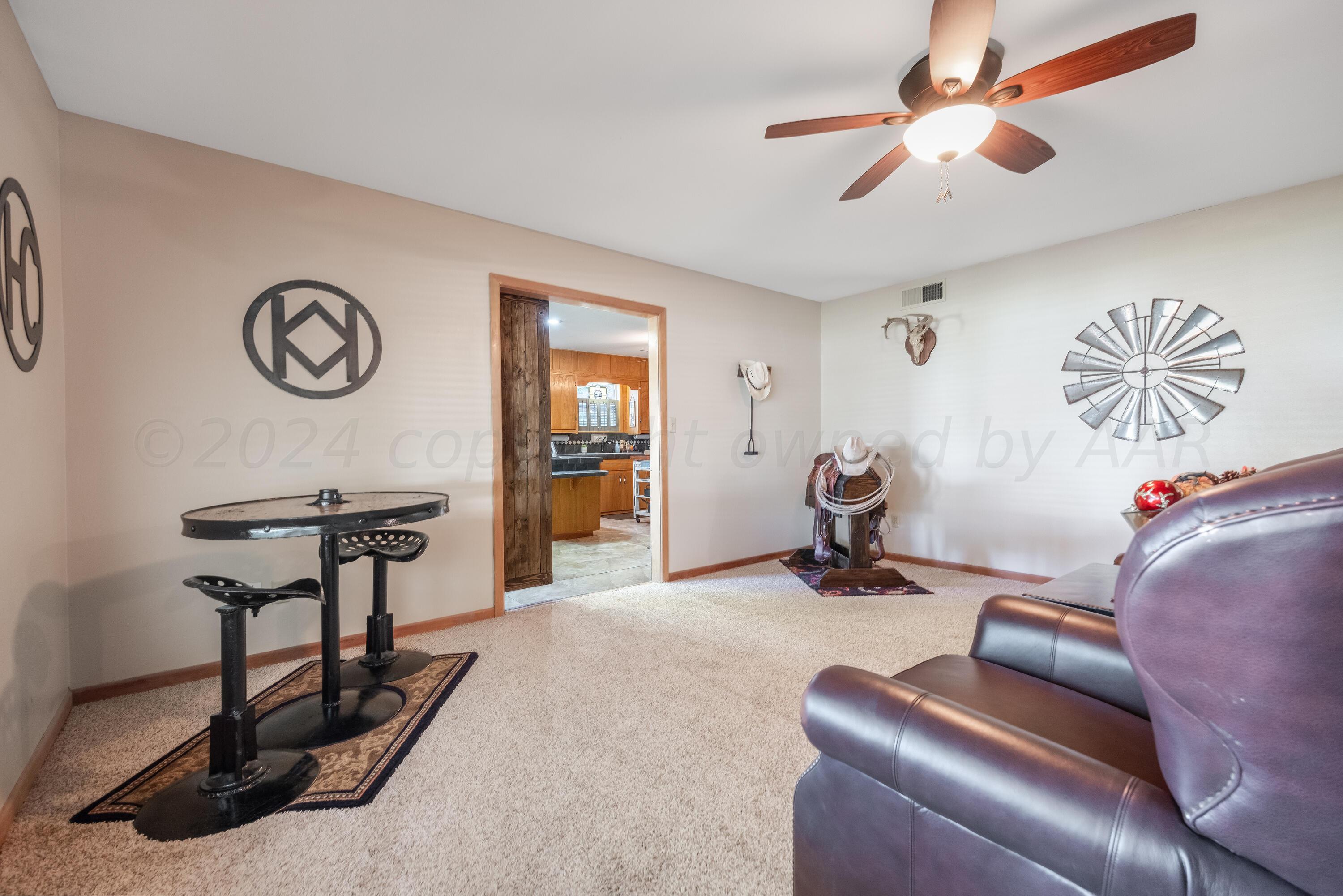 511 Cheyenne Street Wheeler, TX 79096 - Photo 5 of 45 a living room with furniture a clock and a ceiling fan