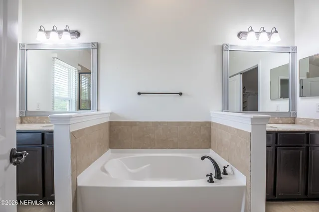 a bathroom with a bathtub sink and mirror
