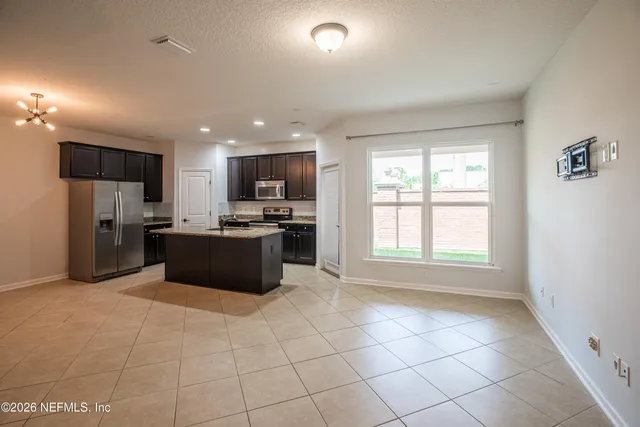 a large kitchen with a large counter top stainless steel appliances and cabinets